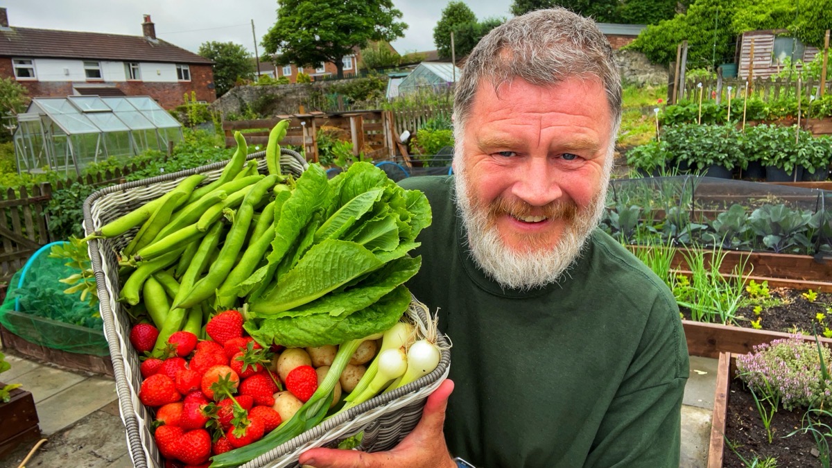 Tony with a basket of harvested vegetables